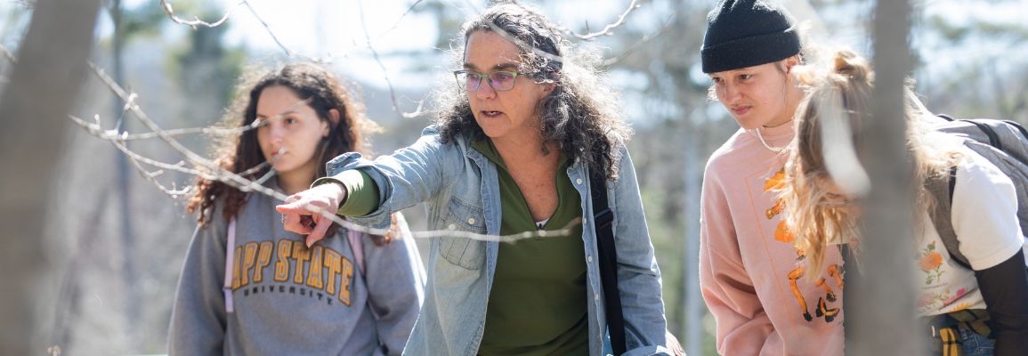 A professor with students in the field.